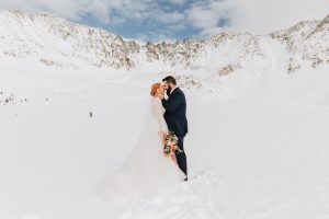 A snowy Colorado elopement starting in a cozy cabin and ending with a hike in the mountains. By Alicia D’Elia Photography, Colorado elopement photographer.