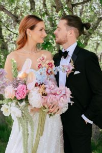 A vibrant summer wedding at The Oaks in Colorado featuring Alena Leena bridal and bold florals by Eleven Blooms Floral.