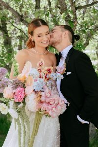 A vibrant summer wedding at The Oaks in Colorado featuring Alena Leena bridal and bold florals by Eleven Blooms Floral.