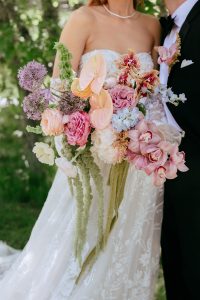 A vibrant summer wedding at The Oaks in Colorado featuring Alena Leena bridal and bold florals by Eleven Blooms Floral.