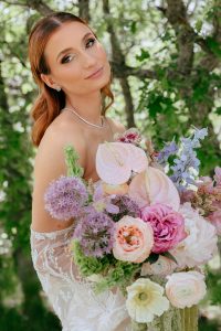 A vibrant summer wedding at The Oaks in Colorado featuring Alena Leena bridal and bold florals by Eleven Blooms Floral.