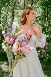 A vibrant summer wedding at The Oaks in Colorado featuring Alena Leena bridal and bold florals by Eleven Blooms Floral.