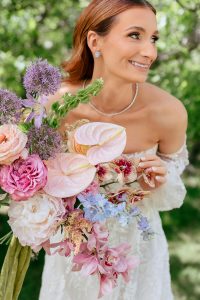 A vibrant summer wedding at The Oaks in Colorado featuring Alena Leena bridal and bold florals by Eleven Blooms Floral.