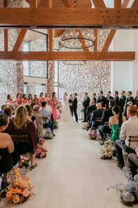 A vibrant summer wedding at The Oaks in Colorado featuring Alena Leena bridal and bold florals by Eleven Blooms Floral.