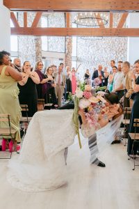 A vibrant summer wedding at The Oaks in Colorado featuring Alena Leena bridal and bold florals by Eleven Blooms Floral.