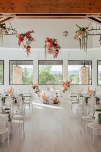 A vibrant summer wedding at The Oaks in Colorado featuring Alena Leena bridal and bold florals by Eleven Blooms Floral.