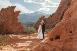 An intimate Garden of the Gods elopement in Colorado Springs with red rocks, mountain backdrops and private vows. Featuring a custom Caribis couture dress.